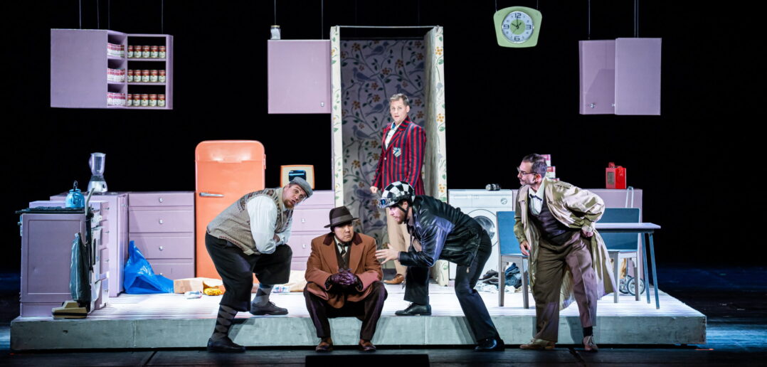 Five characters gather on stage in a set that looks like a house. Falstaff's henchmen are among them.